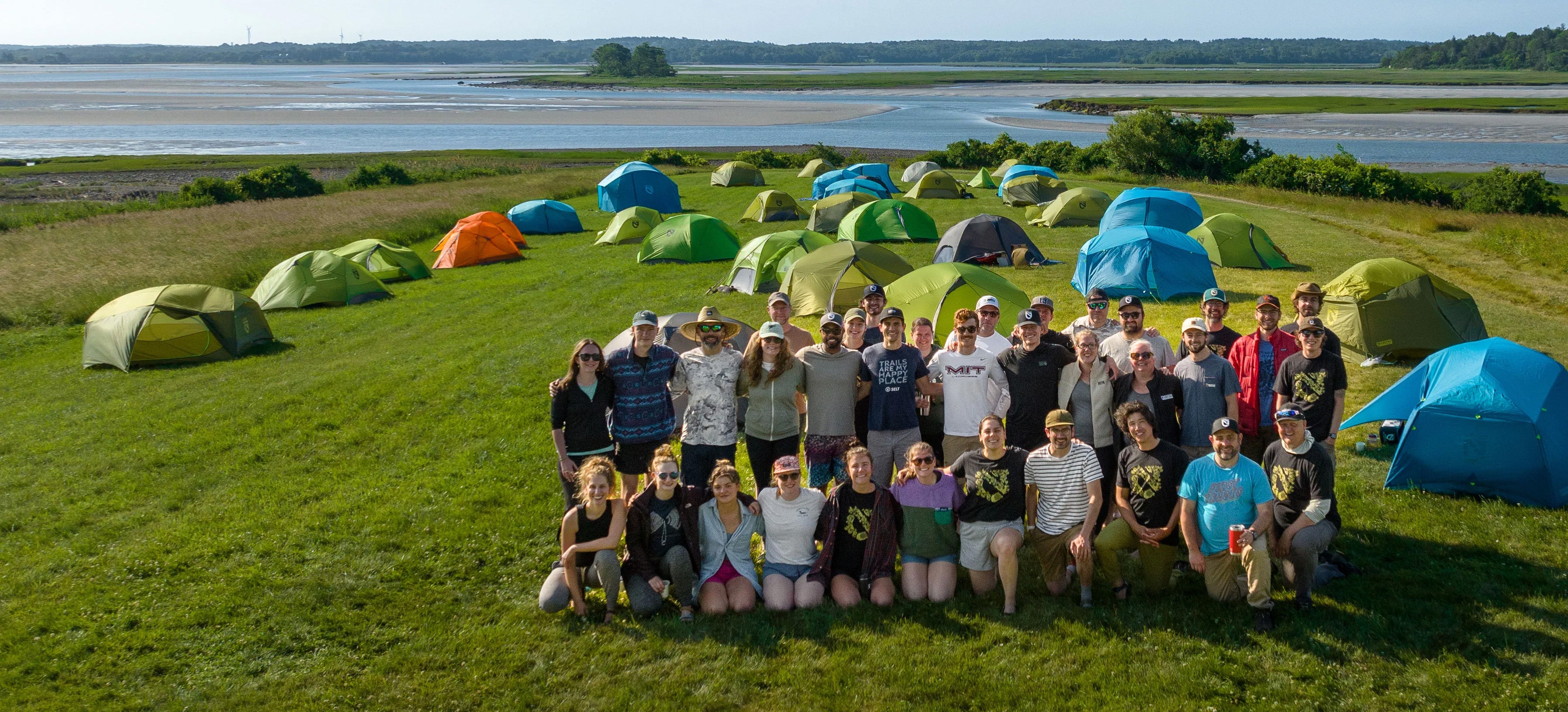 A group of people posing in front of tents.